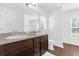 Bathroom featuring a double vanity with granite countertop and a separate toilet area at 1200 Kellogg Dr, Tavares, FL 32778