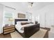 Bright bedroom featuring a modern dark wood bed frame, neutral rug, and contemporary light fixture at 1200 Kellogg Dr, Tavares, FL 32778