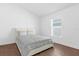 Cozy bedroom with neutral decor, wood floors, and bright natural light at 1200 Kellogg Dr, Tavares, FL 32778
