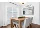 Bright dining area with modern light fixture, table, chairs, and large windows at 1200 Kellogg Dr, Tavares, FL 32778
