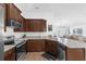 Open kitchen with stainless steel appliances, wood cabinets and views to the living area at 1200 Kellogg Dr, Tavares, FL 32778