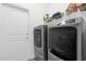 Efficient laundry area with modern gray washer and dryer, plus shelving for storage at 1200 Kellogg Dr, Tavares, FL 32778