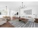 Bright living room with wood floors, modern lighting, and a view into the kitchen at 1200 Kellogg Dr, Tavares, FL 32778