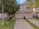 Inviting townhome showcasing a brick driveway, well-manicured lawn, and two-car garage at 1206 Bella Cara Ct, Davenport, FL 33896