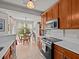 Bright eat-in kitchen featuring wooden cabinetry, modern appliances, and a sunlit breakfast nook overlooking the backyard at 1206 Bella Cara Ct, Davenport, FL 33896