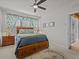 Well-lit main bedroom featuring a ceiling fan, plush carpeting, and ample natural light from the window at 1206 Bella Cara Ct, Davenport, FL 33896