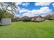 Spacious backyard with lush green grass, a storage shed, and a screened-in patio at 147 13Th Ave, Longwood, FL 32750