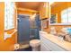 Cozy bathroom with a blue tiled shower, complementing the orange walls and white vanity at 147 13Th Ave, Longwood, FL 32750