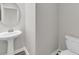 Clean bathroom with white pedestal sink, round mirror, and toilet at 1616 Oak Blossom Dr, Davenport, FL 33837