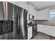 Stainless steel refrigerator and appliances compliment this modern kitchen with white cabinets and gray backsplash at 1616 Oak Blossom Dr, Davenport, FL 33837