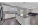 Open concept kitchen with island, white cabinets, grey countertops, stainless appliances, and wood-look floors at 1616 Oak Blossom Dr, Davenport, FL 33837