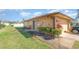 Back exterior of home with partial view of the yard and partial view of the garage at 1644 Piccadilly Dr, Daytona Beach, FL 32117