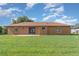 View of backyard displaying house's rear elevation, windows, and sliding glass door at 1644 Piccadilly Dr, Daytona Beach, FL 32117