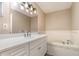 Bathroom featuring double sinks, large mirror, soaker tub, and white cabinets at 1644 Piccadilly Dr, Daytona Beach, FL 32117