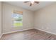 Bedroom features wood-look flooring, a window, and neutral walls at 1644 Piccadilly Dr, Daytona Beach, FL 32117