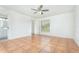 Spacious bedroom features a ceiling fan, closet, and adjacent bathroom with tile flooring at 1644 Piccadilly Dr, Daytona Beach, FL 32117