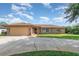 Charming single-story brick home with a well-manicured lawn and a spacious driveway at 1644 Piccadilly Dr, Daytona Beach, FL 32117