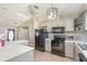 Kitchen features grey cabinets and stainless appliances with tile backsplash at 1644 Piccadilly Dr, Daytona Beach, FL 32117