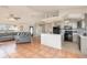 Open-concept living room and kitchen with tiled floors, neutral colors, and plenty of natural light at 1644 Piccadilly Dr, Daytona Beach, FL 32117