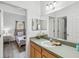 Bright bathroom featuring a vanity with ample counter space, a large mirror, and a view into the bedroom at 16613 Caribbean Breeze Way # 34714, Clermont, FL 34714