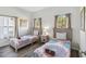 Bright bedroom featuring two twin beds with colorful patterned bedding, arched windows, and neutral curtains at 16613 Caribbean Breeze Way # 34714, Clermont, FL 34714