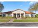 Charming High Grove Clubhouse exterior with lush landscaping, red tile roof and inviting entrance for community gatherings at 16613 Caribbean Breeze Way # 34714, Clermont, FL 34714