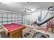 Spacious game room features a billiard table, basketball hoop and ceiling fan, perfect for entertaining at 16613 Caribbean Breeze Way # 34714, Clermont, FL 34714