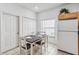 Eat-in kitchen area with a dining table set for four, white appliances, and tile flooring at 16613 Caribbean Breeze Way # 34714, Clermont, FL 34714