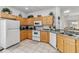Well-lit kitchen featuring white appliances, light cabinetry, and a tiled floor at 16613 Caribbean Breeze Way # 34714, Clermont, FL 34714