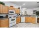 Bright kitchen with light wood cabinets, modern appliances, and tile flooring at 16613 Caribbean Breeze Way # 34714, Clermont, FL 34714