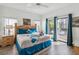 Bedroom featuring a king-size bed, wood floors, and sliding glass doors to an outdoor area at 16613 Caribbean Breeze Way # 34714, Clermont, FL 34714
