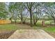 A private backyard featuring mature trees, a wrought iron perimeter fence and a concrete patio at 16817 Gold Star Ct, Clermont, FL 34714