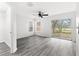 Bright bedroom features gray wood floors, ceiling fan and sliding glass doors to the backyard at 16817 Gold Star Ct, Clermont, FL 34714