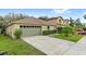 Charming single-Gathering home featuring a two-car garage, green lawn, and an asphalt driveway at 16817 Gold Star Ct, Clermont, FL 34714