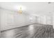 Large living room featuring gray wood floors, large window, and a modern chandelier at 16817 Gold Star Ct, Clermont, FL 34714