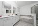 Bright bathroom offers double sinks, soaking tub, and gray tile surround at 171 Bogey Dr, Davenport, FL 33896