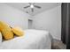 Cozy bedroom features neutral carpet, ceiling fan and white bedding at 171 Bogey Dr, Davenport, FL 33896