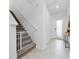 Bright entryway with tile floors, white walls, and staircase with safety gate at 171 Bogey Dr, Davenport, FL 33896