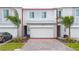 Lovely townhome featuring modern architectural details, a paved driveway, and carefully manicured landscaping at 171 Bogey Dr, Davenport, FL 33896