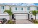 Townhome exterior featuring a two-car garage, neutral paint, and stone accents at 171 Bogey Dr, Davenport, FL 33896