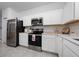 Modern kitchen featuring stainless steel appliances, white cabinetry, and light countertops at 171 Bogey Dr, Davenport, FL 33896