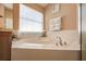 Bright bathroom featuring a soaking tub and lots of natural light from the window at 1949 Manatee Dr, Kissimmee, FL 34759