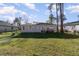 Rear view of the home with well-maintained lawn, golf cart, and solar panels on the roof at 1959 9Th Ave, Deland, FL 32724