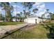 A single-story home with a paved driveway and two-car garage amidst a lush, treed lawn at 1959 9Th Ave, Deland, FL 32724