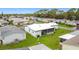 Aerial view of the house including the white roof, lawn, and screen room at 200 Patricia Pl, Davenport, FL 33897