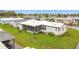An aerial view of the home, featuring landscaping, a carport, and a screen room at 200 Patricia Pl, Davenport, FL 33897