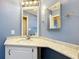 Bathroom featuring blue walls and a vanity with a stone countertop and a golden faucet at 200 Patricia Pl, Davenport, FL 33897