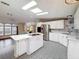 Bright kitchen featuring white cabinets, stainless steel appliances, an island, and unique mosaic tile flooring at 200 Patricia Pl, Davenport, FL 33897