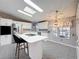 Bright kitchen featuring white cabinets, stainless steel appliances, an island, and mosaic tile flooring at 200 Patricia Pl, Davenport, FL 33897