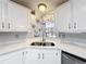 Kitchen featuring white cabinets, granite countertops, stainless steel sink, and a window at 200 Patricia Pl, Davenport, FL 33897